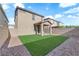 An expansive backyard showcases a covered patio and lush artificial grass, perfect for entertaining and relaxation at 5677 Asyma Ct, Las Vegas, NV 89113