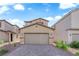 Two-story home featuring a two car garage and desert landscaping for low maintenance living at 5677 Asyma Ct, Las Vegas, NV 89113