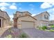 Two-story home with two car garage and desert landscaping in front yard for minimal upkeep at 5677 Asyma Ct, Las Vegas, NV 89113