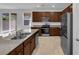 Charming kitchen featuring stainless steel appliances, granite counters, and brown wood cabinetry at 5677 Asyma Ct, Las Vegas, NV 89113