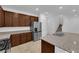 Charming kitchen featuring stainless steel appliances, granite counters, and brown wood cabinetry at 5677 Asyma Ct, Las Vegas, NV 89113