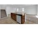 Granite countertop island with sink and dishwasher plus staircase to the second floor at 5677 Asyma Ct, Las Vegas, NV 89113