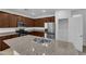 Charming kitchen featuring stainless steel appliances, granite counters, and brown wood cabinetry at 5677 Asyma Ct, Las Vegas, NV 89113