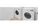 A well-lit laundry room with white washer and dryer units on light tile flooring at 5677 Asyma Ct, Las Vegas, NV 89113