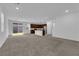 Open floor plan with carpeted living room and kitchen with stainless steel appliances at 5677 Asyma Ct, Las Vegas, NV 89113