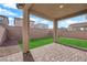 Cozy covered patio with brick pavers and a view of the low-maintenance artificial grass yard at 5677 Asyma Ct, Las Vegas, NV 89113