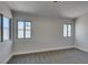 A bright bedroom with three windows, neutral walls, and soft carpeting at 5742 Forsythe Dr, Las Vegas, NV 89142
