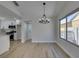 Open dining space with modern chandelier and wood-look floors, adjacent to kitchen at 5742 Forsythe Dr, Las Vegas, NV 89142