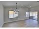 Open dining room featuring wood floors, modern lighting fixture, and sliding glass doors to the backyard at 5742 Forsythe Dr, Las Vegas, NV 89142
