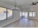 Bright dining room with wood floors, modern chandelier, ceiling fan, and sliding glass doors to the backyard at 5742 Forsythe Dr, Las Vegas, NV 89142