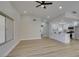 Spacious living room and kitchen with wood-look floors, ceiling fan, and recessed lighting at 5742 Forsythe Dr, Las Vegas, NV 89142