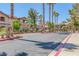 Community entrance with lush landscaping, mature trees, and secure gate at 5751 E Hacienda Ave # 159, Las Vegas, NV 89122