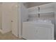 Convenient laundry room featuring modern washer, dryer, and open shelving at 5751 E Hacienda Ave # 159, Las Vegas, NV 89122