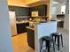 Cozy kitchen featuring sleek dark cabinets, a breakfast bar with stools, and modern appliances at 5855 Valley Dr # 2092, North Las Vegas, NV 89031