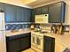 Well-equipped kitchen with white appliances, dark cabinets, and a stylish backsplash at 5855 Valley Dr # 2092, North Las Vegas, NV 89031