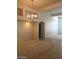 Neutral dining room featuring modern chandelier, paneled walls, carpet, tile, and open concept design at 6245 Hawthorn Woods Ave, Las Vegas, NV 89130