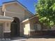 Beige two-story home featuring arched entryway, neutral tones, rock accents, and drought-resistant landscaping at 6245 Hawthorn Woods Ave, Las Vegas, NV 89130