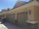 Two car garage with painted doors, stone veneer accents, decorative lights, and street number at 6245 Hawthorn Woods Ave, Las Vegas, NV 89130