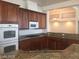 Updated kitchen with stainless steel appliances, granite countertops, tile floors, and wooden cabinets at 6245 Hawthorn Woods Ave, Las Vegas, NV 89130