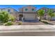 Inviting home with a two-car garage, complemented by a brick driveway and mature landscaping at 6313 Voss St, North Las Vegas, NV 89081