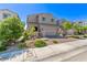 Well-kept home featuring a two-car garage, brick-paved driveway, and lush landscaping in the front yard at 6313 Voss St, North Las Vegas, NV 89081