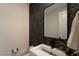 Chic powder room with stone accent wall, modern sink, and sleek black faucet at 6486 Vanhoven Crest St, Las Vegas, NV 89166