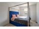 Stylish bedroom with a blue, tufted headboard and ample natural light from the window at 6486 Vanhoven Crest St, Las Vegas, NV 89166