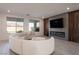 Stylish living room with modern fireplace, wood accent wall, and sleek tile flooring at 6486 Vanhoven Crest St, Las Vegas, NV 89166