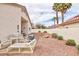Backyard featuring desert landscaping, outdoor seating and patio with sun shade at 672 Hitchen Post Dr, Henderson, NV 89011