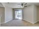 Well-lit living room with neutral walls, plush carpeting, a modern ceiling fan, and a sliding glass door to the outside at 6800 E Lake Mead Blvd # 2072, Las Vegas, NV 89156