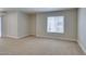 Carpeted living room featuring a large window with blinds at 6800 E Lake Mead Blvd # 2072, Las Vegas, NV 89156
