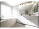 Bathroom featuring a soaking tub, double vanity, and neutral wall color at 7037 Tilligerry St, North Las Vegas, NV 89084