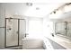 Bright bathroom with a glass-enclosed shower, soaking tub, double vanity, and modern fixtures at 7037 Tilligerry St, North Las Vegas, NV 89084