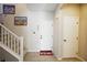 Inviting foyer featuring tiled floors, staircase, and a festive welcome mat for a warm entry at 7037 Tilligerry St, North Las Vegas, NV 89084