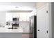 Bright kitchen featuring white cabinetry, stainless steel appliances, and a quartz countertop island at 7037 Tilligerry St, North Las Vegas, NV 89084