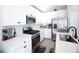 Modern kitchen with white cabinets, stainless steel appliances, and ample counter space at 7037 Tilligerry St, North Las Vegas, NV 89084