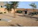 Open picnic area offers shaded seating and recreational space for outdoor enjoyment, with a cornhole game and mature landscaping at 7037 Tilligerry St, North Las Vegas, NV 89084