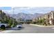 Neighborhood street view with houses and cars, with mountains visible in the distance at 7037 Tilligerry St, North Las Vegas, NV 89084
