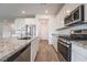 Kitchen features a granite countertop island, stainless appliances and wood-look flooring at 7124 Sayonara Vista St, North Las Vegas, NV 89084