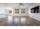 Bright and airy living room with wood-style flooring, a ceiling fan, and large windows at 7124 Sayonara Vista St, North Las Vegas, NV 89084
