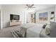 Light, bright main bedroom features neutral carpet, a ceiling fan, and a sliding glass door to balcony at 7124 Sayonara Vista St, North Las Vegas, NV 89084