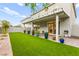 Lush backyard with artificial grass, a covered patio, and tasteful landscaping at 7502 Lush Oasis Ave, Las Vegas, NV 89113