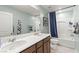 The bathroom has a double sink, large mirror, and shower with a curtain rod at 7502 Lush Oasis Ave, Las Vegas, NV 89113
