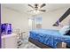This bedroom includes a ceiling fan, a window and gaming console on a white desk at 7502 Lush Oasis Ave, Las Vegas, NV 89113
