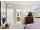 Bedroom boasts an adjacent bathroom, TV, dresser, and a window allowing natural light at 7502 Lush Oasis Ave, Las Vegas, NV 89113