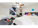 This bedroom boasts creative wall paint, a ceiling fan, a window, and gaming console on a desk at 7502 Lush Oasis Ave, Las Vegas, NV 89113