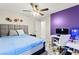 This bedroom features a ceiling fan, a large window, a bed, and a desk with a gaming console at 7502 Lush Oasis Ave, Las Vegas, NV 89113