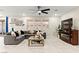 Spacious living room with a comfortable sectional sofa and a large windows for natural light at 7502 Lush Oasis Ave, Las Vegas, NV 89113