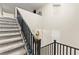 Carpeted staircase with black railings leads to the upper level, enhancing the home's architectural design at 7502 Lush Oasis Ave, Las Vegas, NV 89113