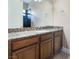 Bathroom vanity featuring granite countertop, wood cabinets, and a large mirror at 761 Romano Ln, Henderson, NV 89012
